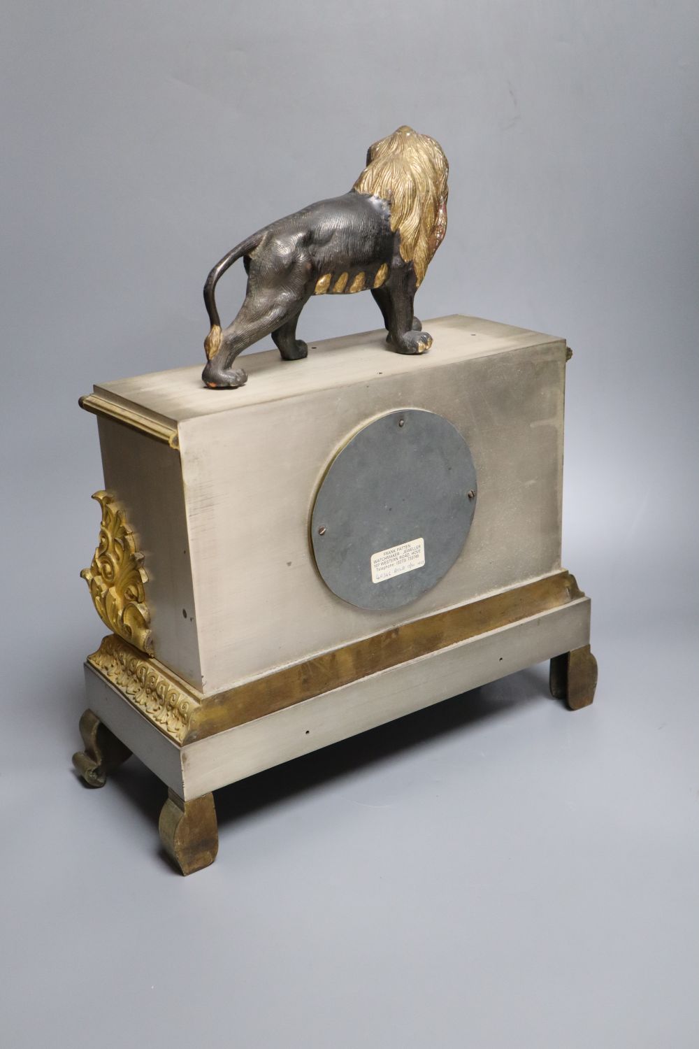 A French gilt and silvered mantel clock, with associated lion surmount, height 40cm